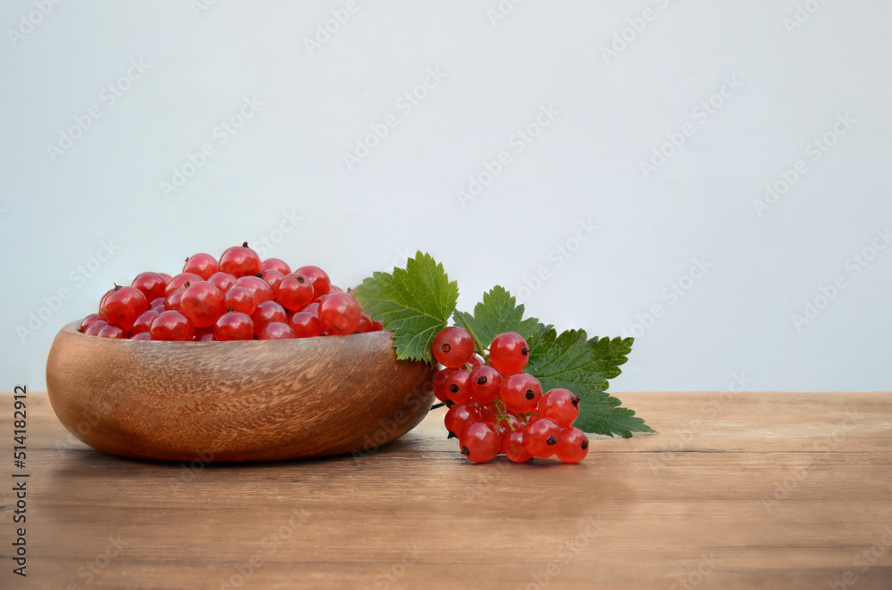 wooden table with a plate of juicy red currants on a light background for your inscription wooden table with a plate of juicy red currants on a light background for your inscription