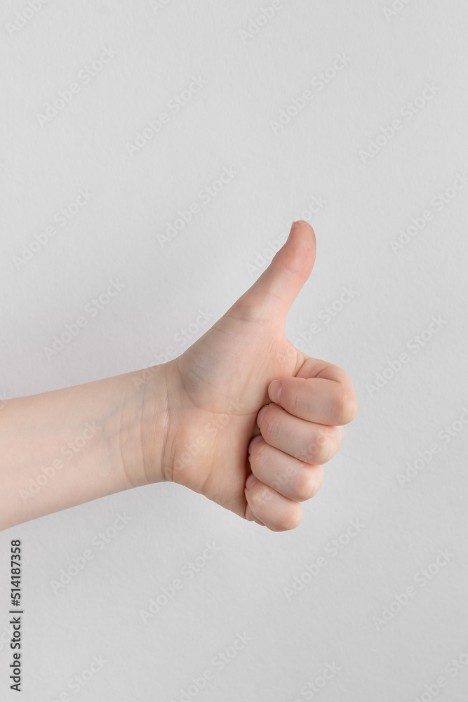 hand of kids or child hand showing thumbs up Isolated on white and gray background