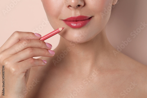 Young woman with beautiful pink lip pencil on light background  closeup