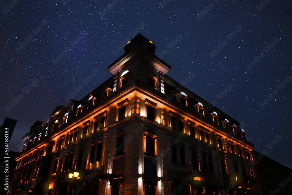 Exterior of beautiful illuminated building on starry night, low angle view