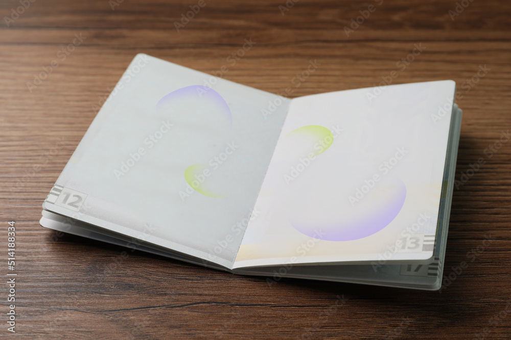 Blank open passport on wooden table, closeup Blank open passport on wooden table, closeup