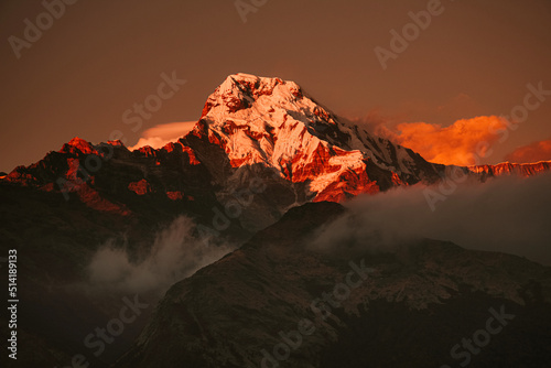 Canvas Print Warm pink and orange dramatic sunrise light over Annapurna mountain range with b