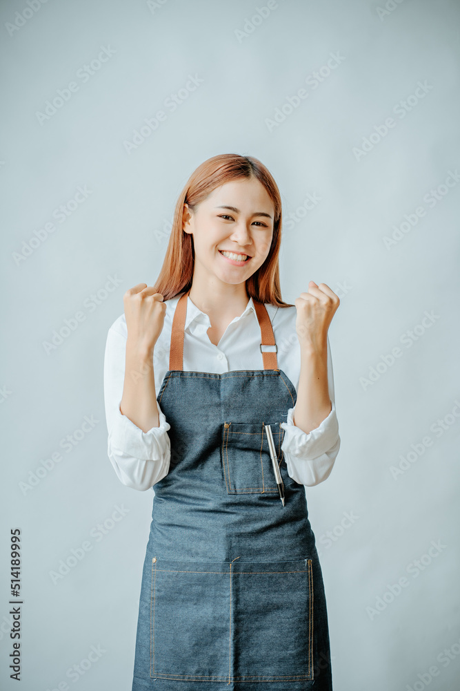 Happy young Asian woman raising her fist on a white background Happy young Asian woman raising her fist on a white background