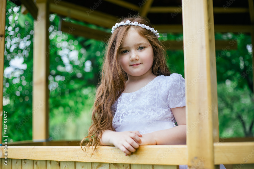 Redhead armenian little girl in garden posing for camera and smiling
