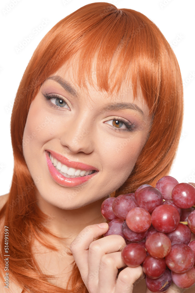 Beautiful redhead young woman with red grapes posing isolated on white background Beautiful redhead young woman with red grapes posing isolated on white background