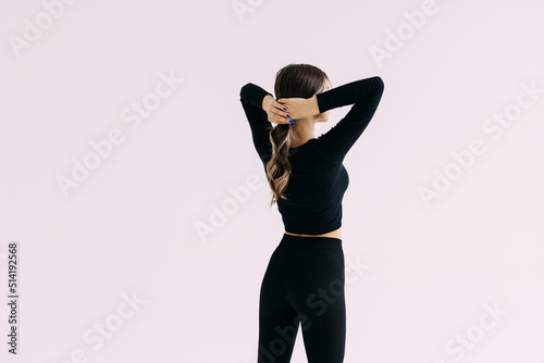Attractive young woman in sportswear posing on white background. Sexy and sensual brunette woman with perfect body posing in studio isolated over white background with copyspace.