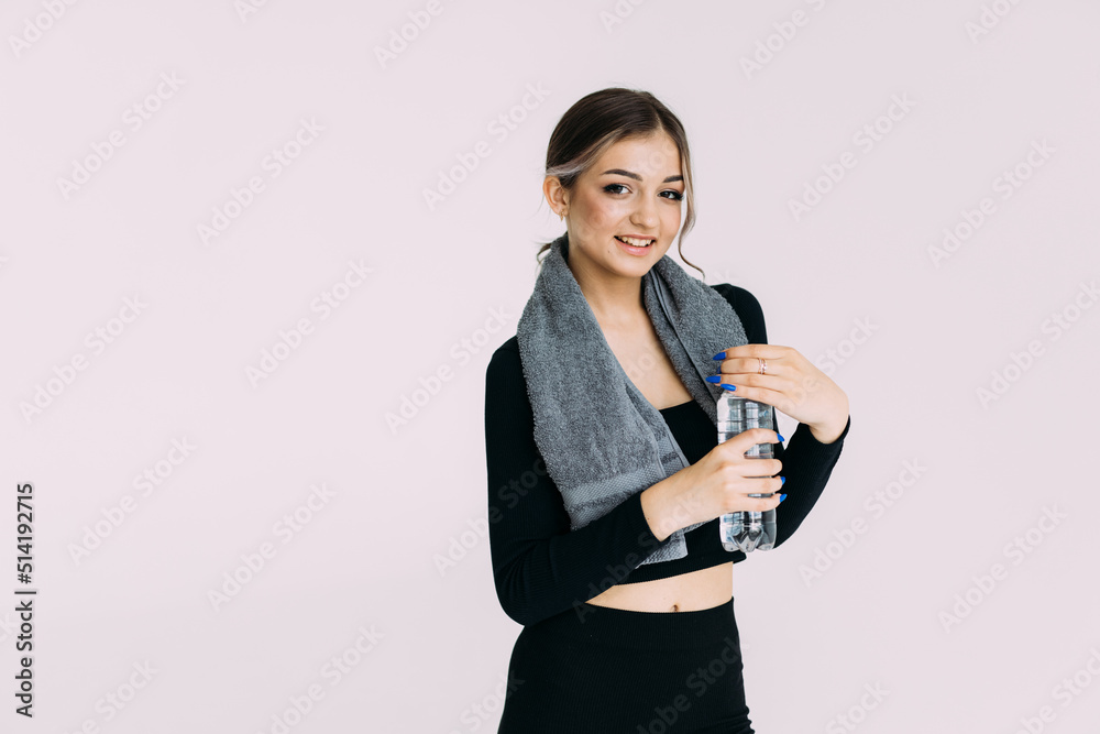 Portrait of a fit healthy woman with gym towel and water bottle on white background Portrait of a fit healthy woman with gym towel and water bottle on white background