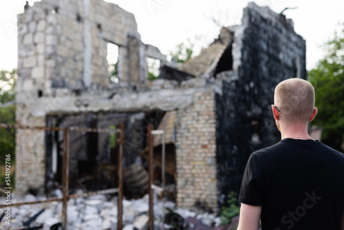 Man looking to his ruined and burnt house by russian troops. © Vitalina