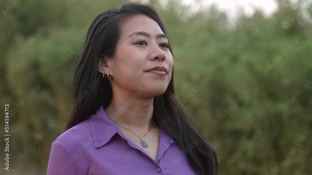 Portrait of asian woman standing in nature forest, breathing fresh air, contemplating nature at dusk. Chinese female enjoys a calm life of peace, quiet in the park. Happiness and Satisfaction Portrait of asian woman standing in nature forest, breathing fresh air, contemplating nature at dusk. Chinese female enjoys a calm life of peace, quiet in the park. Happiness and Satisfaction