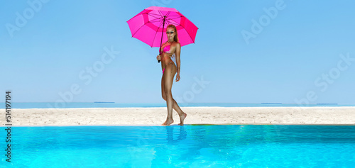 Sexy woman in bikini with pink umbrella near the pool at Maldives tropical island. Elegant female model in pink swimsuit near the pool. Perfect body bikini model. Bikini fashion. Luxury travel.