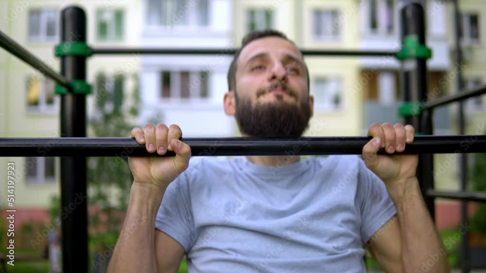 A man of Arab appearance on pull -up bars does exercises. Fitness Sport Street training. Muscles in the public gym. A man of Arab appearance on pull -up bars does exercises. Fitness Sport Street training. Muscles in the public gym.