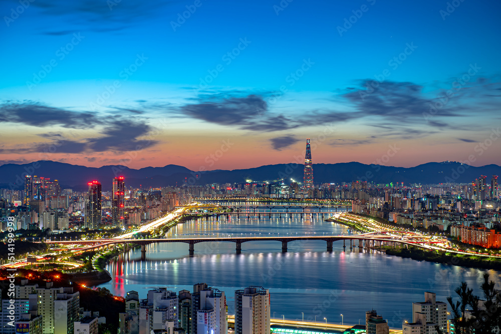 City landscape with flowing river before sunrise

