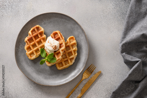 Trendy delicious croffles with whipped cream on a gray background. Croissant as waffle. View from above. Copy space. photo