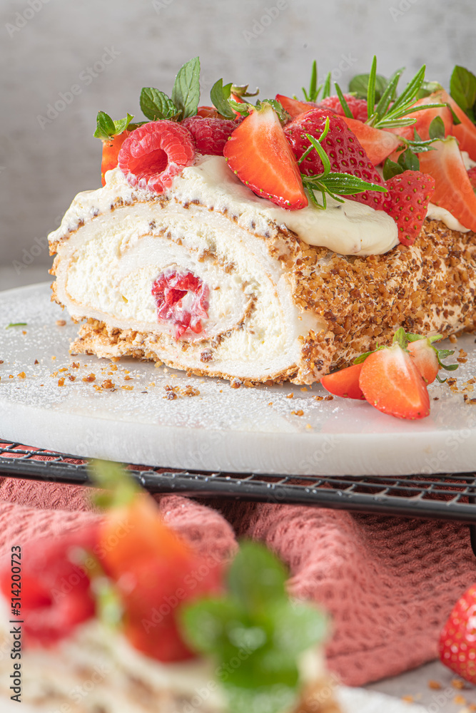 Meringue roll with a gentle airy cream, crunchy peanut, mint, rosemary and filling with raspberries and strawberries. Pavlova summer sweet dessert Meringue roll with a gentle airy cream, crunchy peanut, mint, rosemary and filling with raspberries and strawberries. Pavlova summer sweet dessert