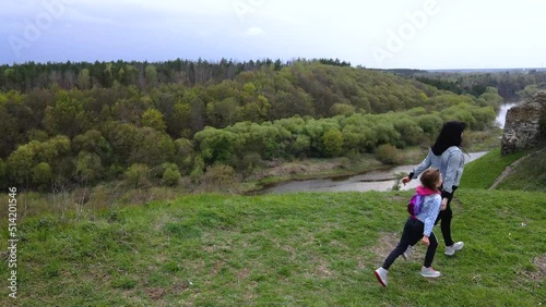 Mother and daughter run on the coast Sluch river hills photo