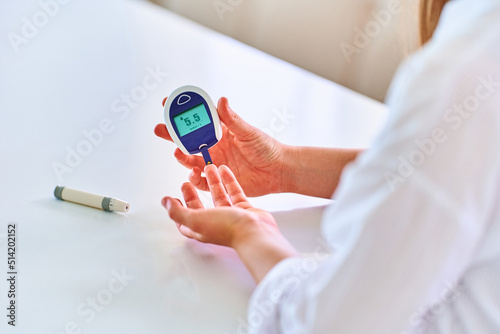 Female using glucose meter for measuring and monitoring blood level. Healthcare and mellitus diabetes treatment