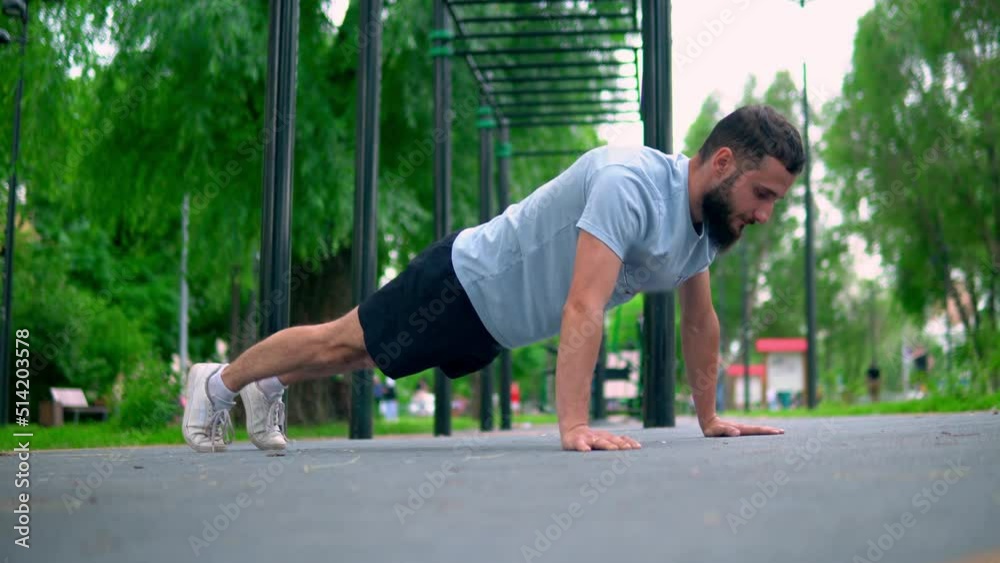The Arab man performs exercises compressed from the floor in the street in a public place. Indoor fitness -training The Arab man performs exercises compressed from the floor in the street in a public place. Indoor fitness -training