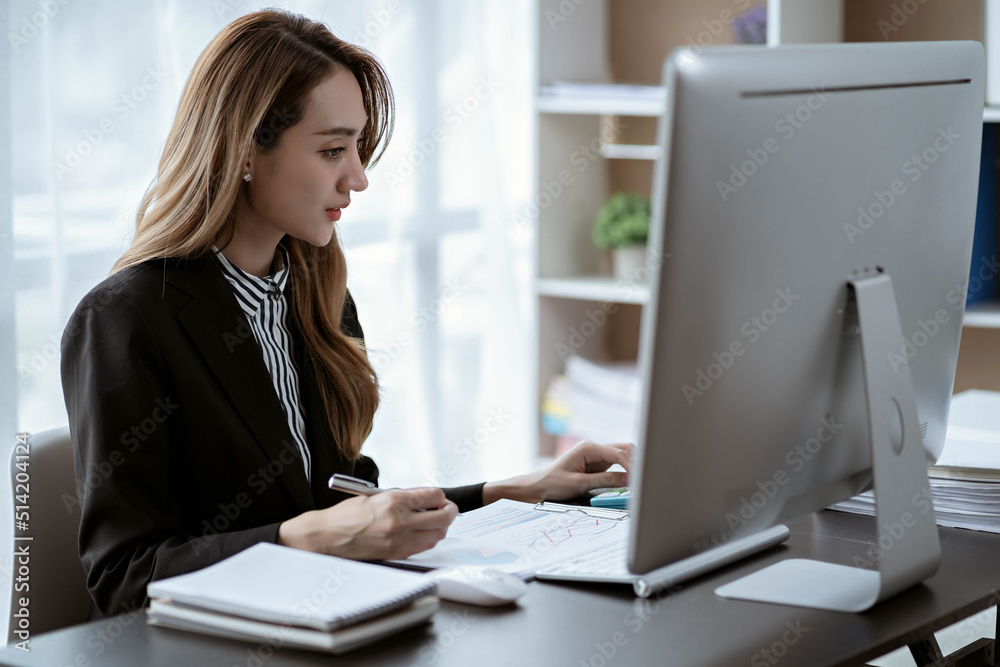 Asian businesswoman in formal suit in office happy and cheerful during using smartphone and working Asian businesswoman in formal suit in office happy and cheerful during using smartphone and working