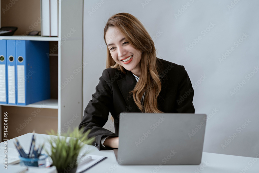 Asian businesswoman in formal suit in office happy and cheerful during using smartphone and working Asian businesswoman in formal suit in office happy and cheerful during using smartphone and working