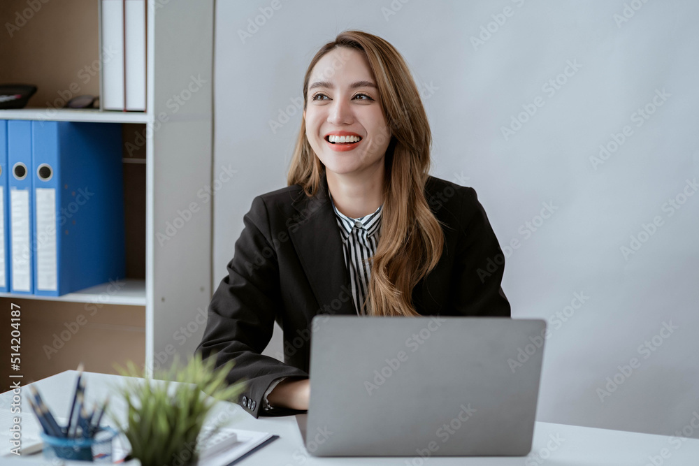 Asian businesswoman in formal suit in office happy and cheerful during using smartphone and working Asian businesswoman in formal suit in office happy and cheerful during using smartphone and working