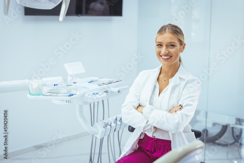 Assure and beautiful dental doctor with brilliant healthy smile all over her face in front of dentist room. Dental Professional. Portrait of female dentist .She standing in her dentist office..