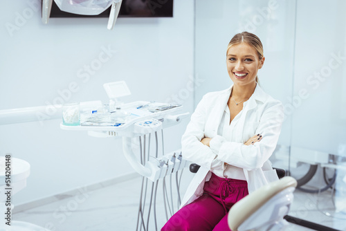 Portrait of female dentist .She standing in her dentist office. Young female dentist in white coat at workplace. Space for text. People, medicine, stomatology and healthcare concept