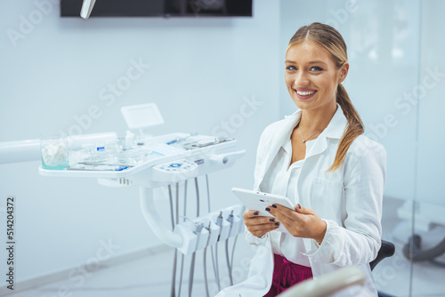 Portrait of female dentist .She standing in her dentist office. Young female dentist in white coat at workplace. Space for text. People  medicine  stomatology and healthcare concept