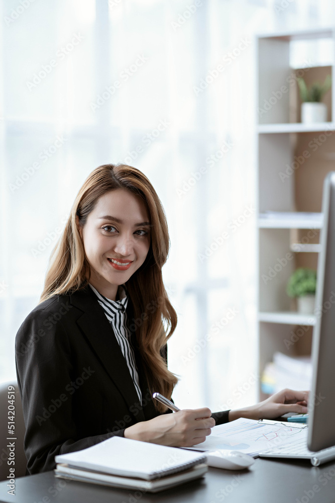 Asian businesswoman in formal suit in office happy and cheerful during using smartphone and working Asian businesswoman in formal suit in office happy and cheerful during using smartphone and working