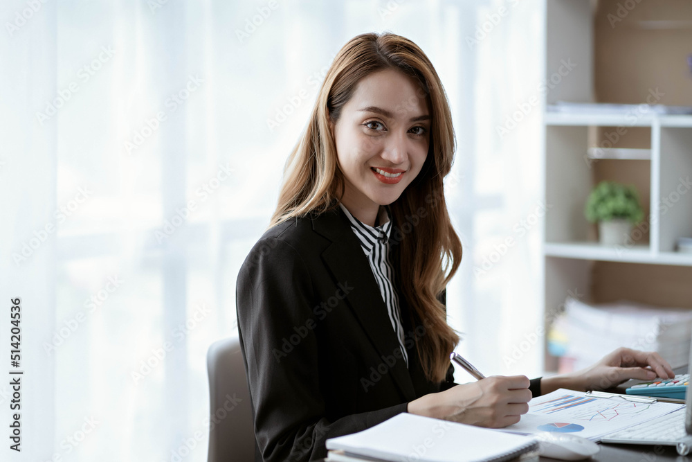 Asian businesswoman in formal suit in office happy and cheerful during using smartphone and working Asian businesswoman in formal suit in office happy and cheerful during using smartphone and working
