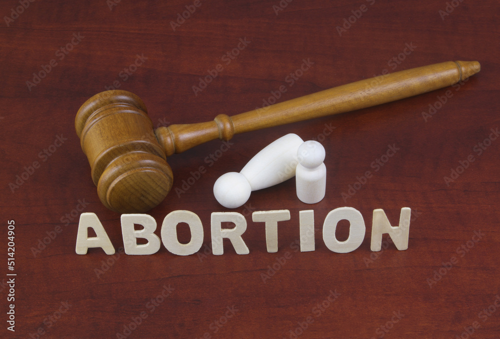 Laws about abortion. Letters abortion with judge gavel and figures of female and child. Laws about abortion. Letters abortion with judge gavel and figures of female and child.