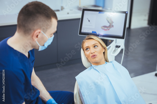 Perfect smile! Part of dentist examining his beautiful patient in dentist office. European young woman smiling while looking at mirror in dental clinic