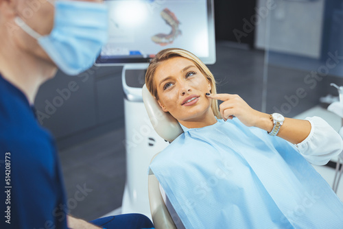 Smiling young woman receiving dental checkup. close up view. Healthcare and medicine concept. Attractive young woman in stomatology clinic with male dentist.
