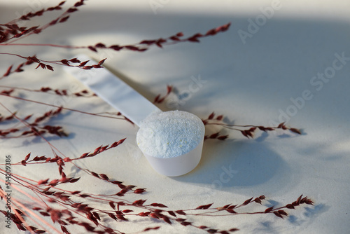 Sport food supplement powder with natural beige background and props. Supplement, creatine, hmb, bcaa, amino acid or vitamine in a white scoop. Sport nutrition healthy life→ Check my profile for more!