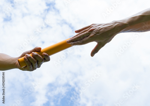 Close up hand set baton from hand to hand on sky background. Business concept for teamwork and team builder.