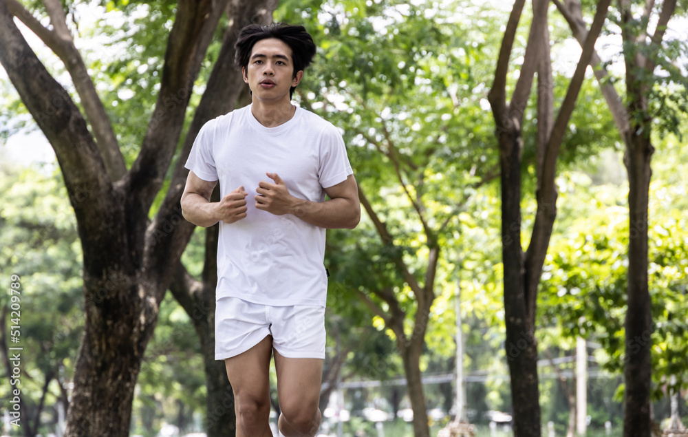 Asian handsome man in white shirt running in park. Concept for health lifestyle in park. Asian handsome man in white shirt running in park. Concept for health lifestyle in park.