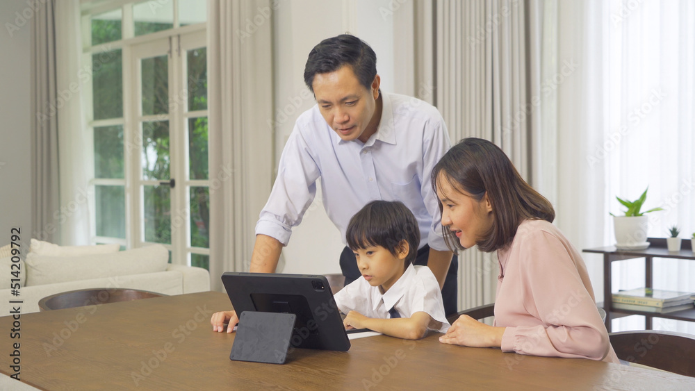 Portrait of happy smiling Asian Family. A student studying homework online from school at home or house in family relationship. Love of father, mother, and son. People lifestyle. Education activity. Portrait of happy smiling Asian Family. A student studying homework online from school at home or house in family relationship. Love of father, mother, and son. People lifestyle. Education activity.