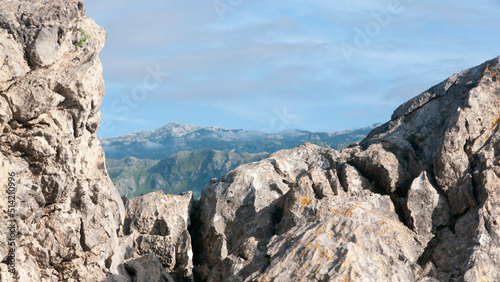 Cordillera montañosa en el horizonte de una playa rocosa
