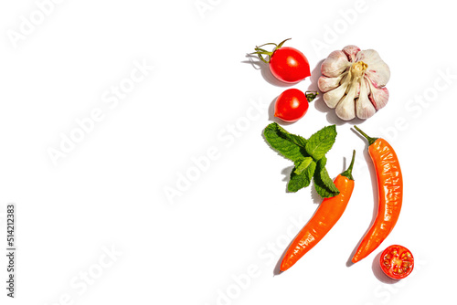 Cooking background with tomato, orange chili peppers, garlic and mint isolated on white background