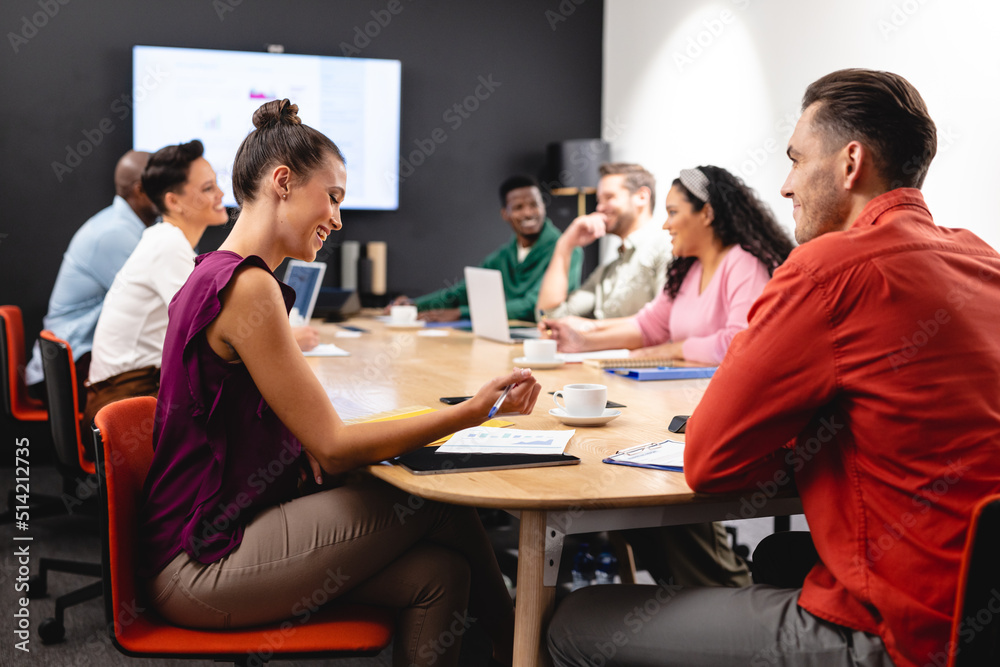 Smiling businessman and businesswoman discussing during meeting at office Smiling businessman and businesswoman discussing during meeting at office