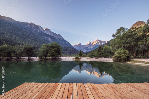 Man on the pier at the Jasna Lake in Kranjska Gora observing the amazing mountain landscape. photo