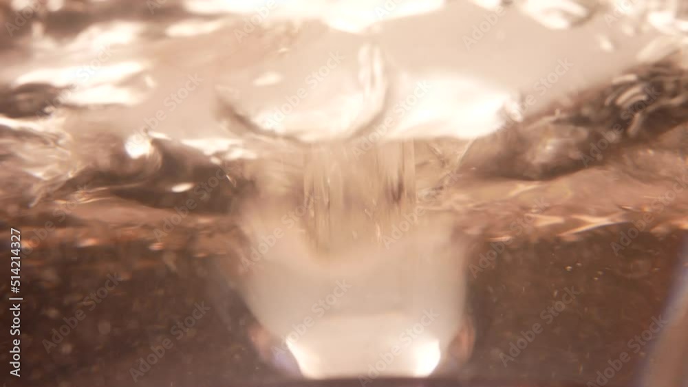 Filming of bubbling liquid in a glass flask of a hookah.