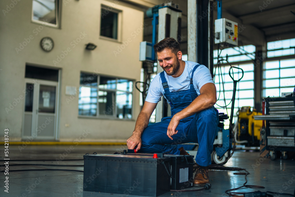 Portrait Shot of a Handsome Mechanic Working on a truck workshop Service. Professional Repairman. Modern Clean Workshop. Portrait Shot of a Handsome Mechanic Working on a truck workshop Service. Professional Repairman. Modern Clean Workshop.