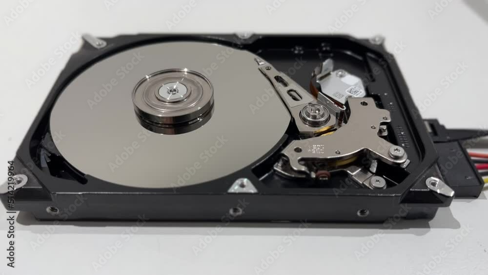 close up of interior of an hard disk drive writing data on the support with its head. close up of interior of an hard disk drive writing data on the support with its head.