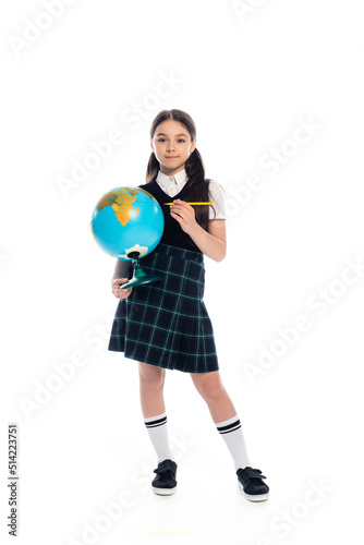 Full length of preteen schoolkid holding pencil and globe on white background.