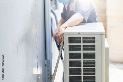 Selective focus of Air conditioner compressor, Repairman washing dirty compartments air conditioner, Male technician cleaning air conditioner indoors