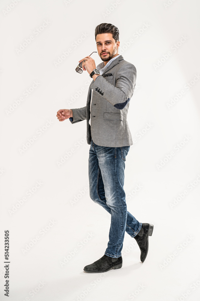Full length photo of handsome man wearing jeans, shirt, elegant jacket and sunglasses. Men's beauty, fashion. Full length photo of handsome man wearing jeans, shirt, elegant jacket and sunglasses. Men's beauty, fashion.