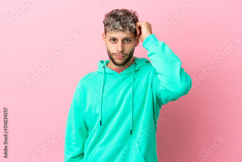 Young handsome caucasian man isolated on pink background with an expression of frustration and not understanding © luismolinero