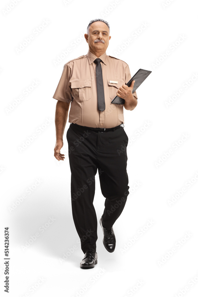 Full length portrait of a security officer holding a clipboard and walking towards camera Full length portrait of a security officer holding a clipboard and walking towards camera