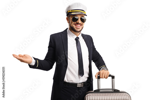 Pilot in a uniform with a suitcase pointing with hand photo