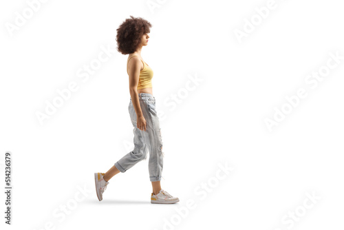 Fotografie Full length profile shot of a young caucasian woman with afro hairstyle walking